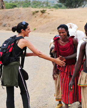 Backpacking woman shaking hands with a group of people